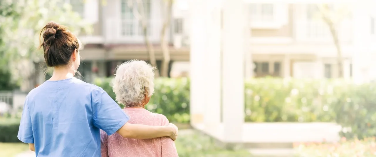 nurse walking with geriatric patient at LTC facility